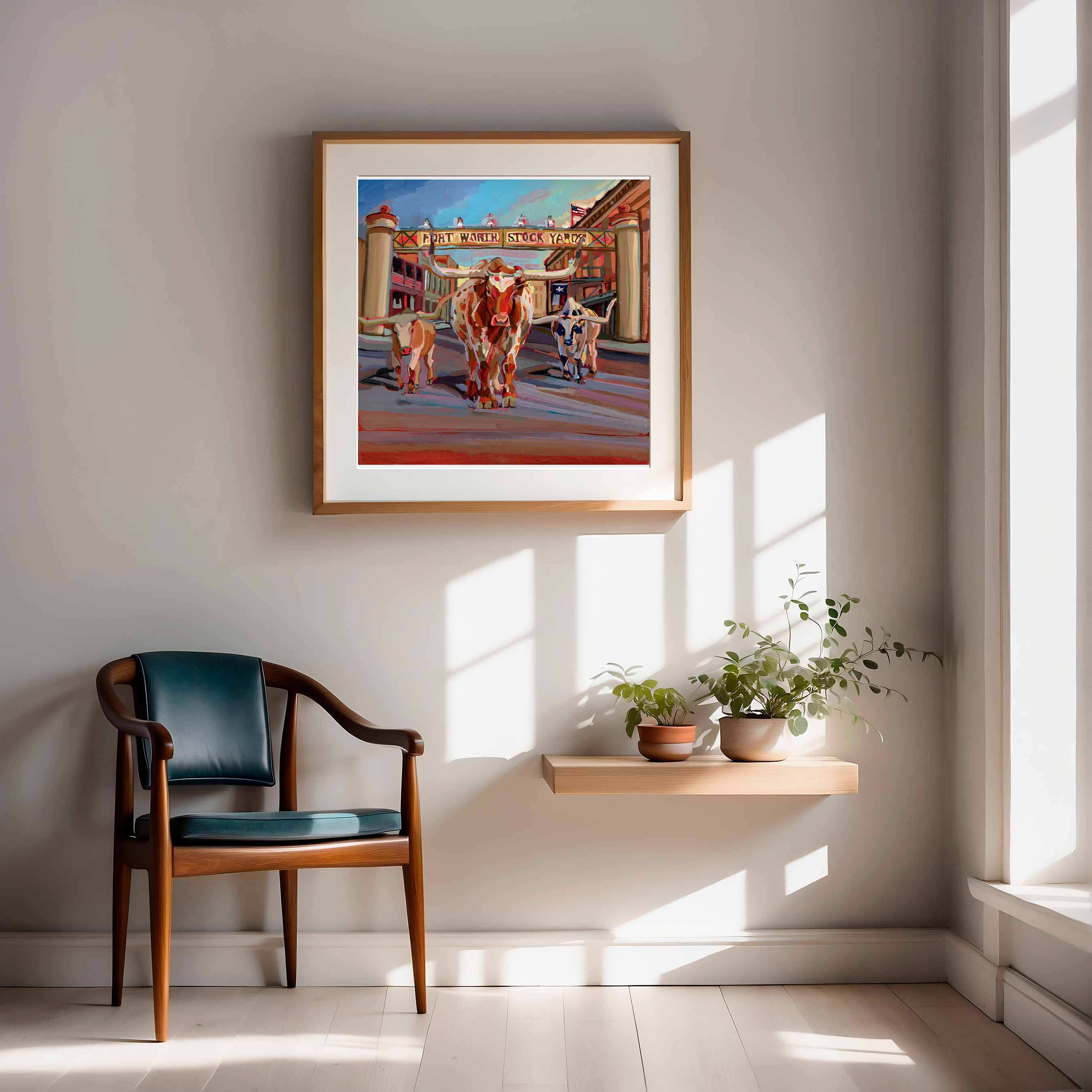 Framed print of original painting of Fort Worth street scene with longhorn cows on a wall in a sunlit room.