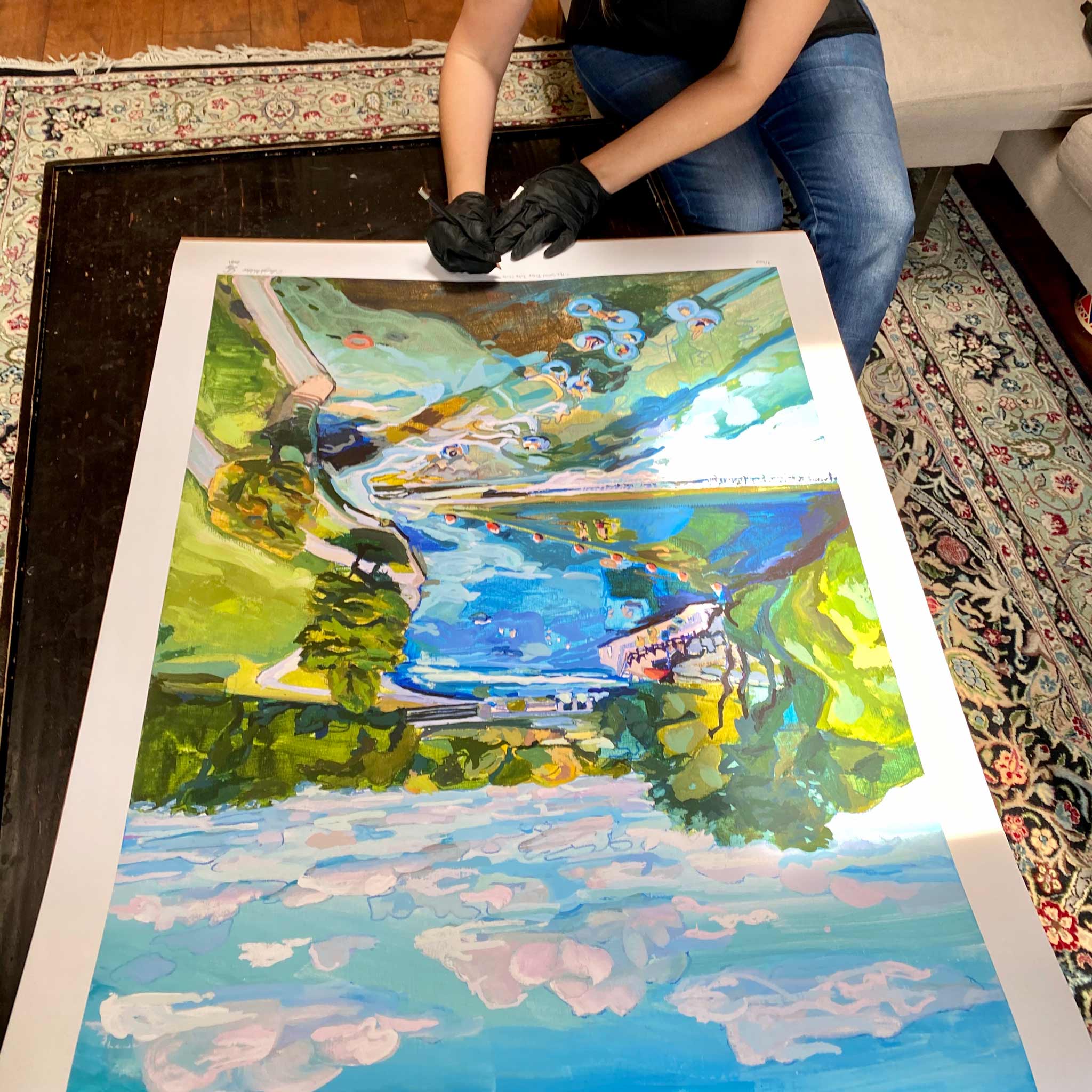 Artist signing 30x40 fine art print of Texas river.