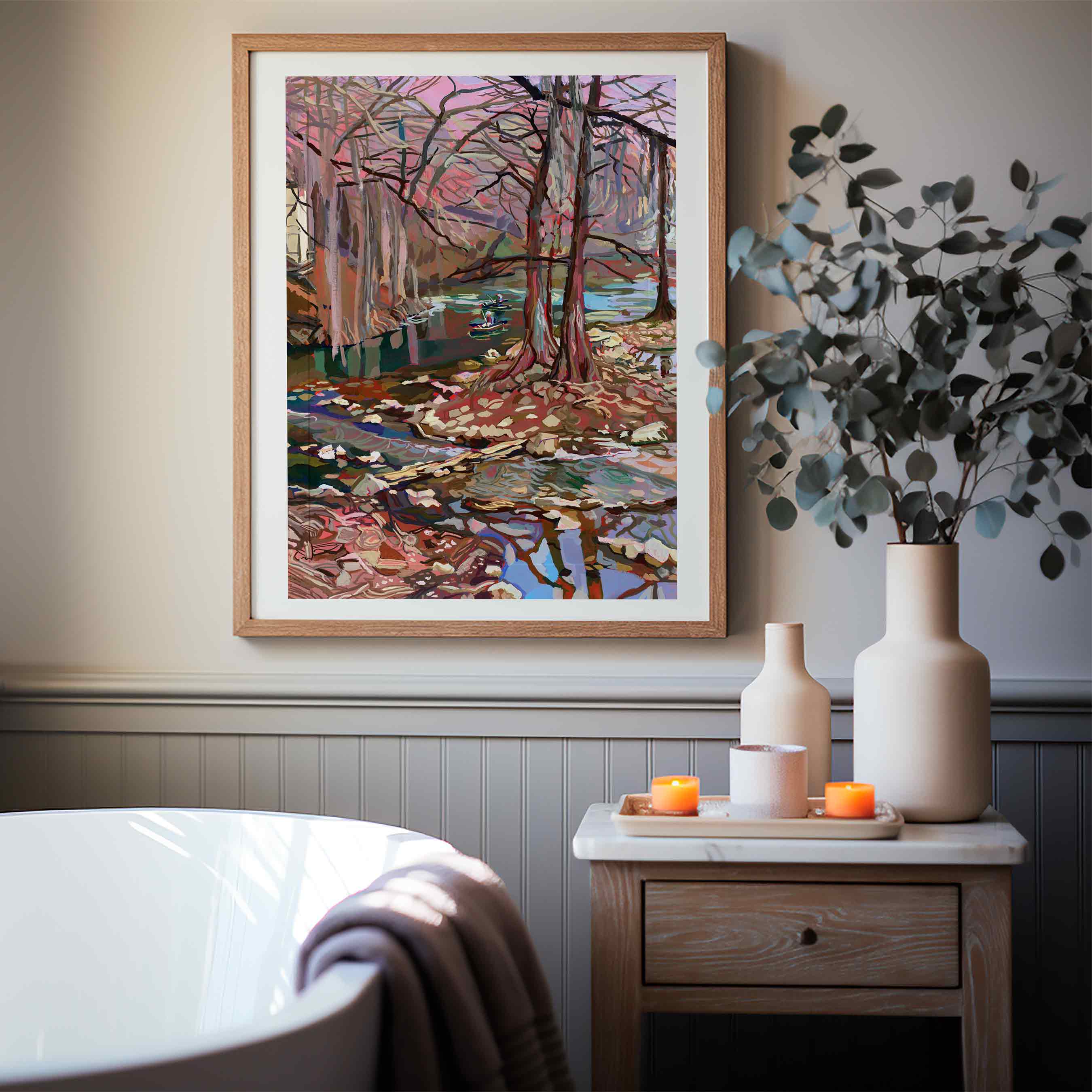 Guadalupe River painting of a landscape with Cypress trees and water on a wall in a 16x20 frame above the bathtub with decorative vases on side table.